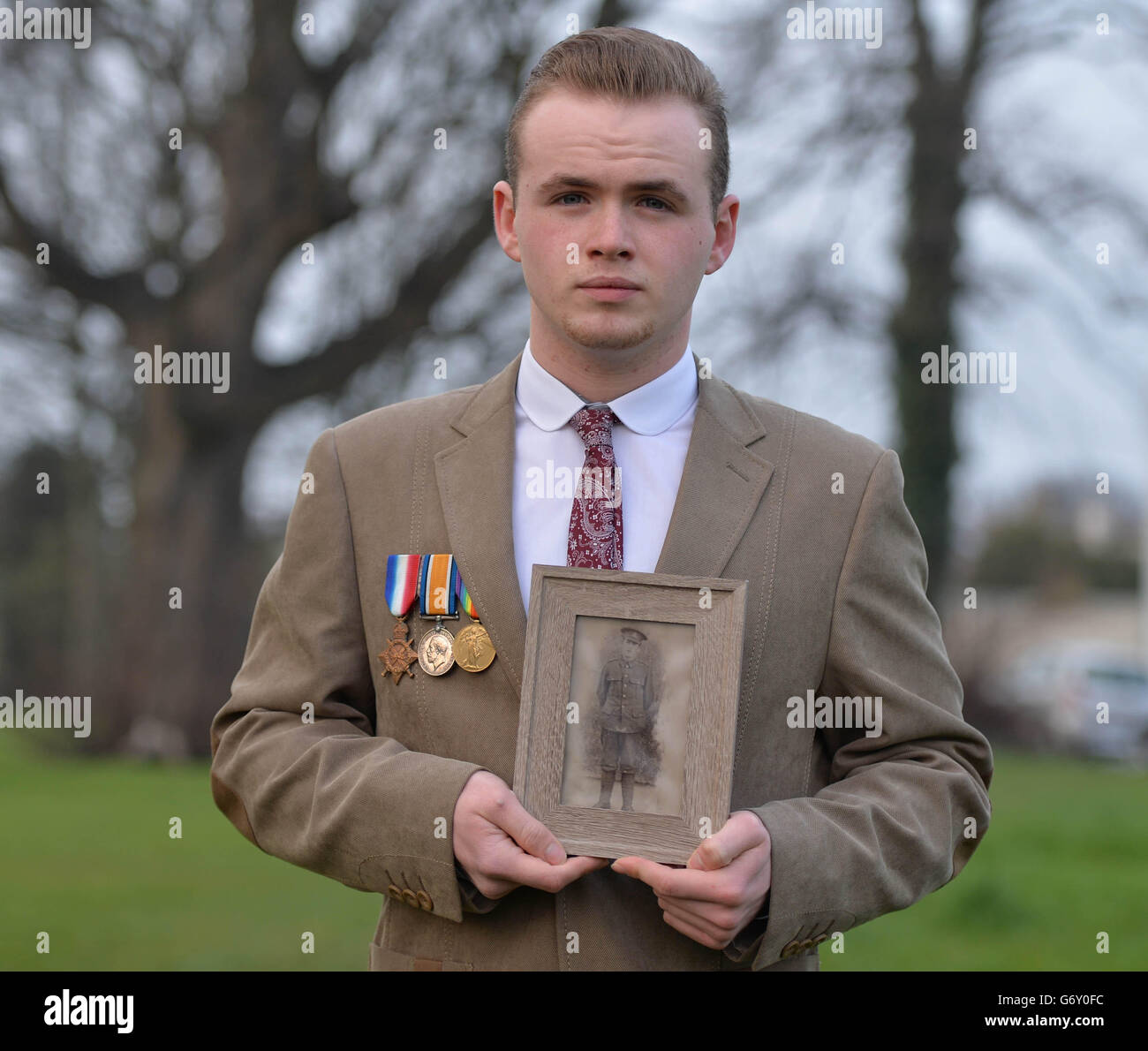 Thomas Halpin with a photo of relative Lance Corporal Patrick Broderick, killed in 1917 in Ypres, as family of Irish war dead and campaigners seek to preserve one of the last remaining British Legion halls in Ireland, gathering at the building in Killester, north Dublin, to plant 50 white crosses - one for every thousand Irishmen who died in the First World War. Stock Photo