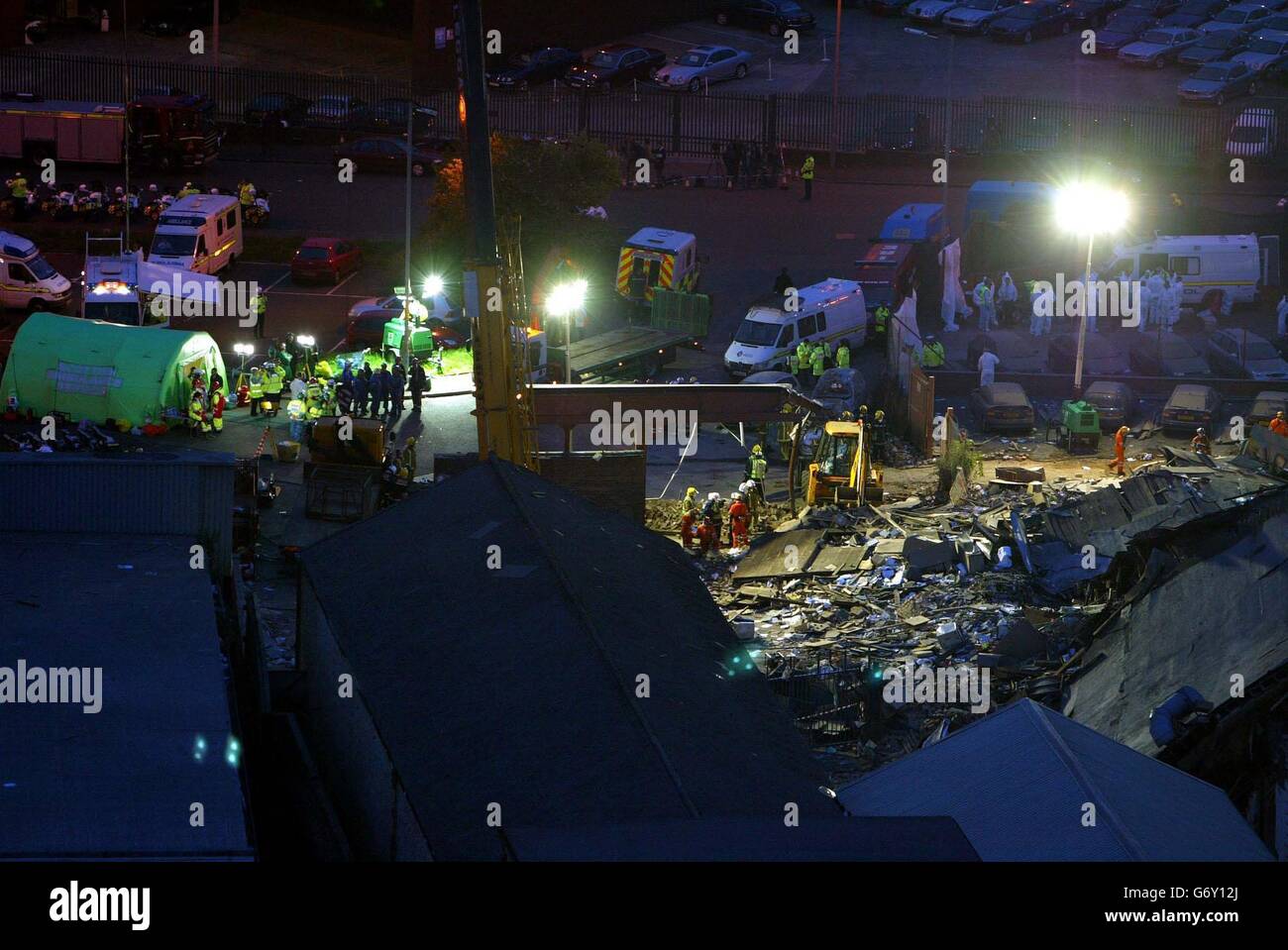 Rescue workers look through the rubble with aid of arc lights at the