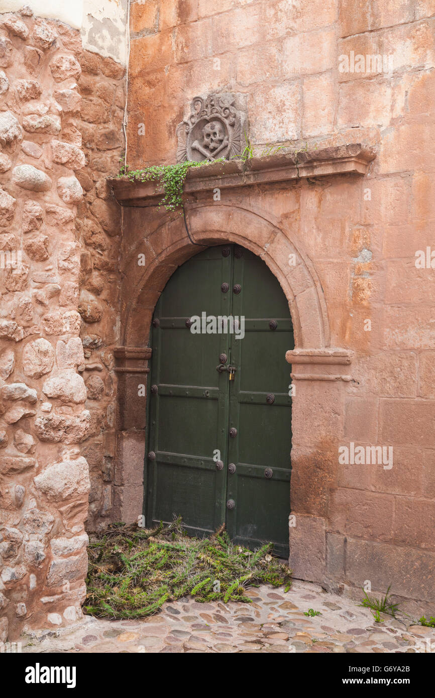 Doorway with skull and crossed bones to the left of the Cusco Cathedral on the Plaza de Armas, behind a small jail. Stock Photo