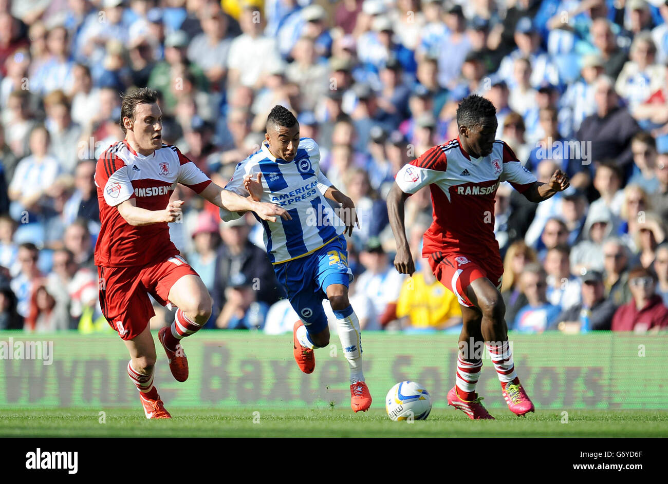 Brighton and Hove Albion's Jesse Lingard (centre) runs between Middlesbrough's Dean Whitehead (left) and Kenneth Omeruo (right) during the Sky Bet League Championship match at the AMEX Stadium, Brighton. Stock Photo