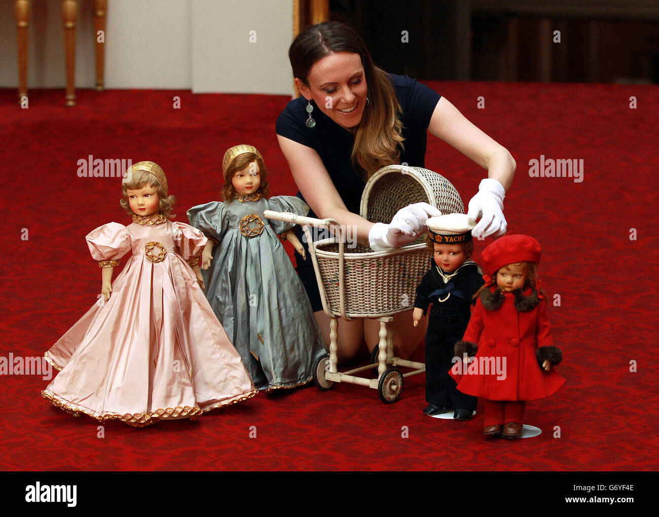 Curator Anna Reynolds holds Parisian dolls that belonged to Queen Elizabeth II and Princess Margaret at the launch of the summer exhibition Royal Childhood at Buckingham Palace, London, which celebrates royal childhood with toys and family gifts belonging to the royal children when they were growing up. Stock Photo