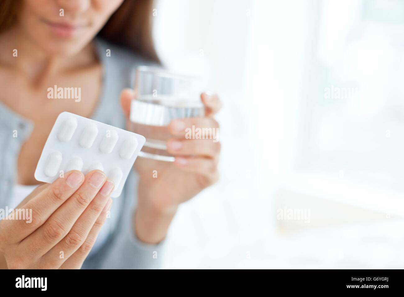 MODEL RELEASED. Young woman holding blister pack. Stock Photo