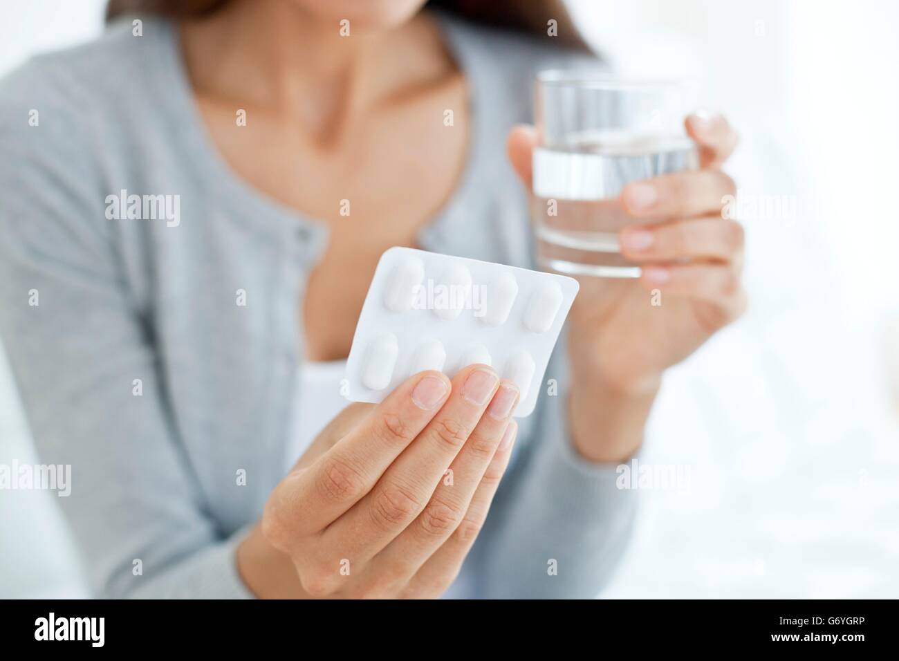 MODEL RELEASED. Young woman holding blister pack. Stock Photo