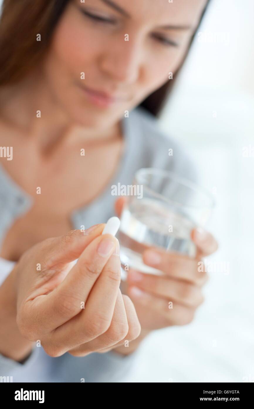 MODEL RELEASED. Young woman taking medicine. Stock Photo