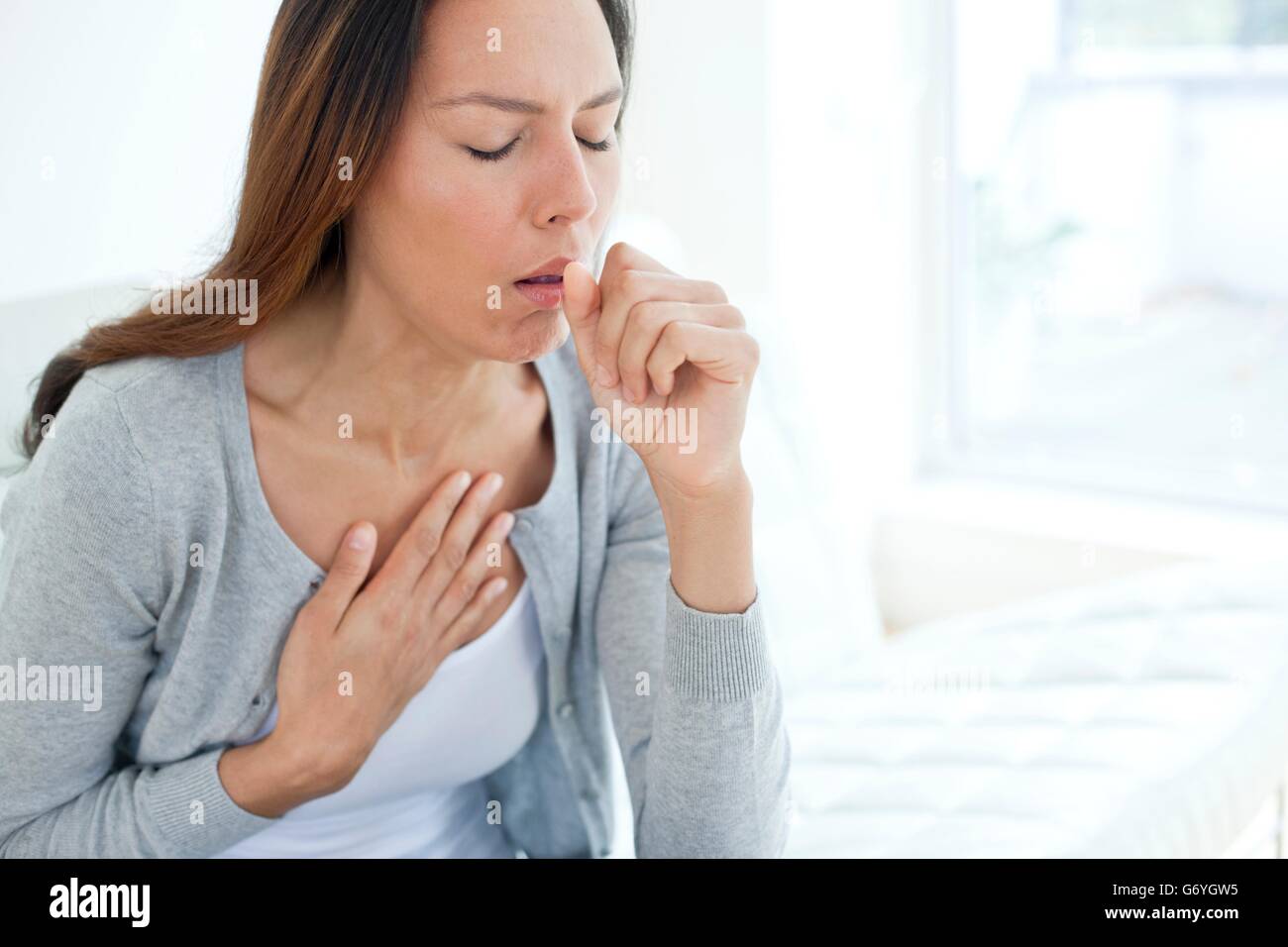 MODEL RELEASED. Young woman coughing. Stock Photo