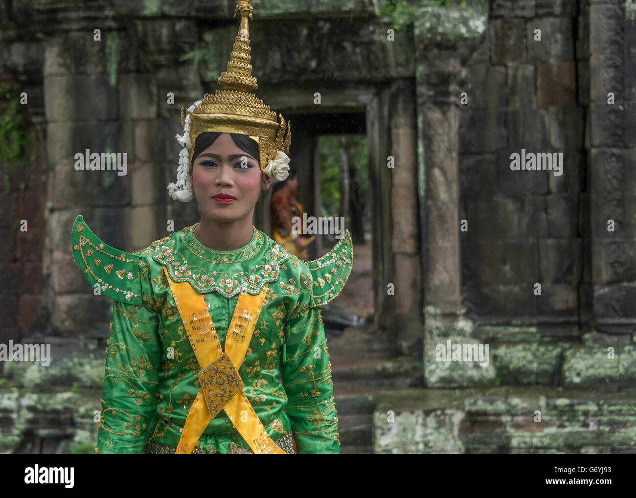 Woman in male Ngoh costume in a light rain, Terrace of the Elephants, Angor Thom, Cambodia Stock Photo