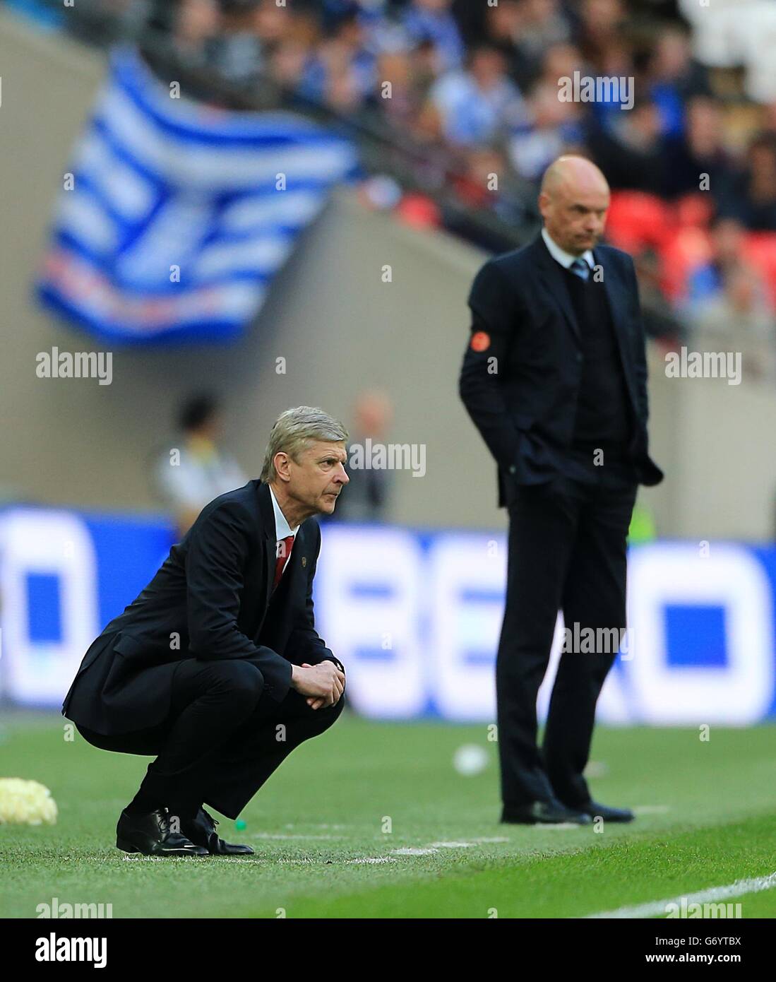 Arsenal's manager Arsene Wenger and Wigan Athletic's manager Uwe Rosler (background) on the touchline. Stock Photo