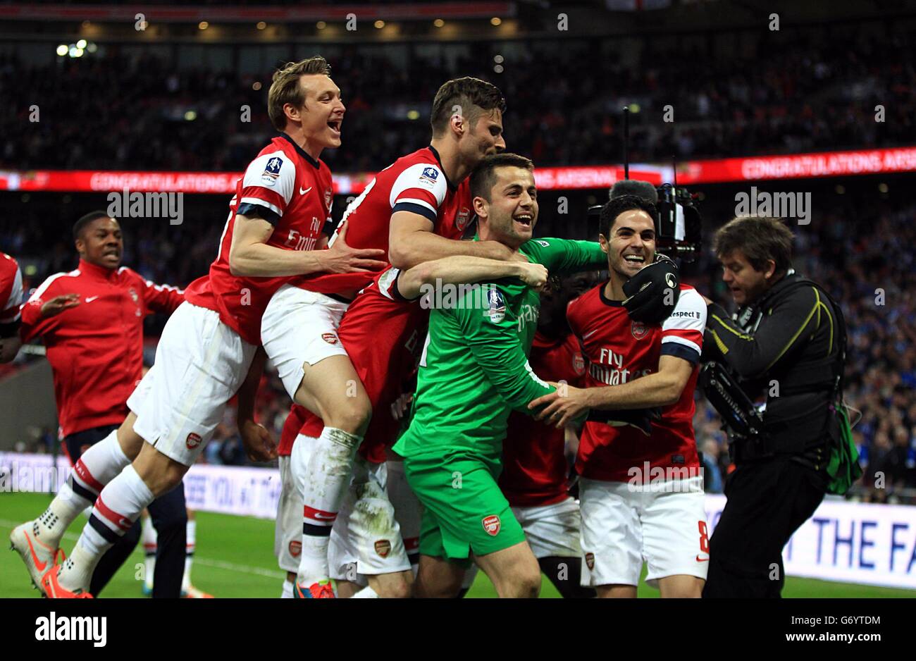 Arsenal's goalkeeper Lukasz Fabianski is mobbed by his team-mates after they win the game on penaltys Stock Photo