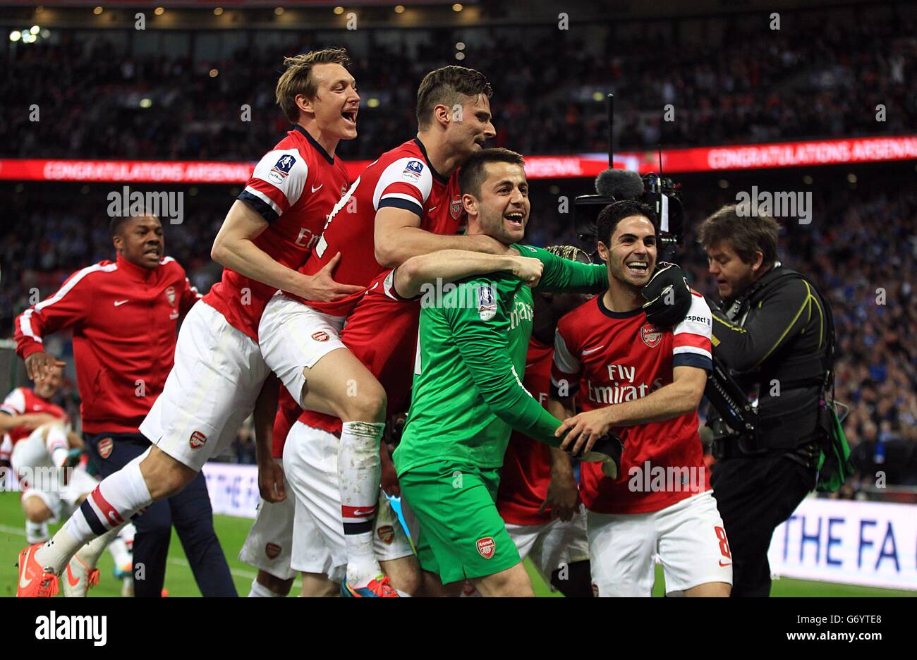 Soccer - FA Cup - Semi Final - Wigan Athletic v Arsenal - Wembley Stadium. Arsenal's goalkeeper Lukasz Fabianski is mobbed by his team-mates after they win the game on penaltys Stock Photo