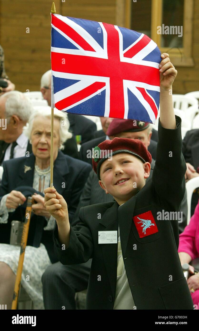 Robbie Ham, 8, from Exeter, waves a Union Flag as veterans of the Glider Pilots Regiment wait for the Prince of Wales to arrive at Pegasus Bridge in north-west France to inaugurate a replica of one of the giant gliders used on D-Day 60 years ago. The prince was in Normandy, north west France, for a day of engagements meeting veterans, and remembering those who lost their lives during the Allied invasion of Europe. Stock Photo