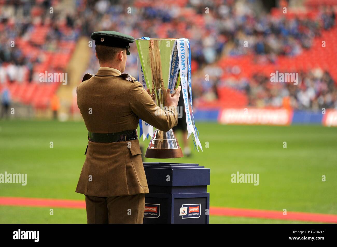 A member of the Armed Forces places the Johnstone's Paint Trophy on it ...