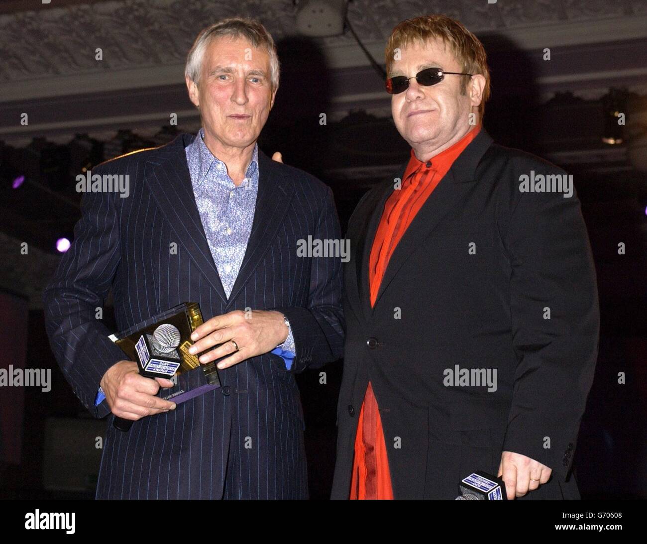 Sir Elton John (right) presents the Gold Award to Radio 2 DJ Johnnie Walker, on stage during the Sony Radio Academy Awards 2004, held at Grosvenor House hotel on Park Lane, London. The ceremony saw Jonathan Ross and Radio 1's Chris Moyles lose out to Xfm's Christian O'Connell, who was named DJ of the Year. Stock Photo
