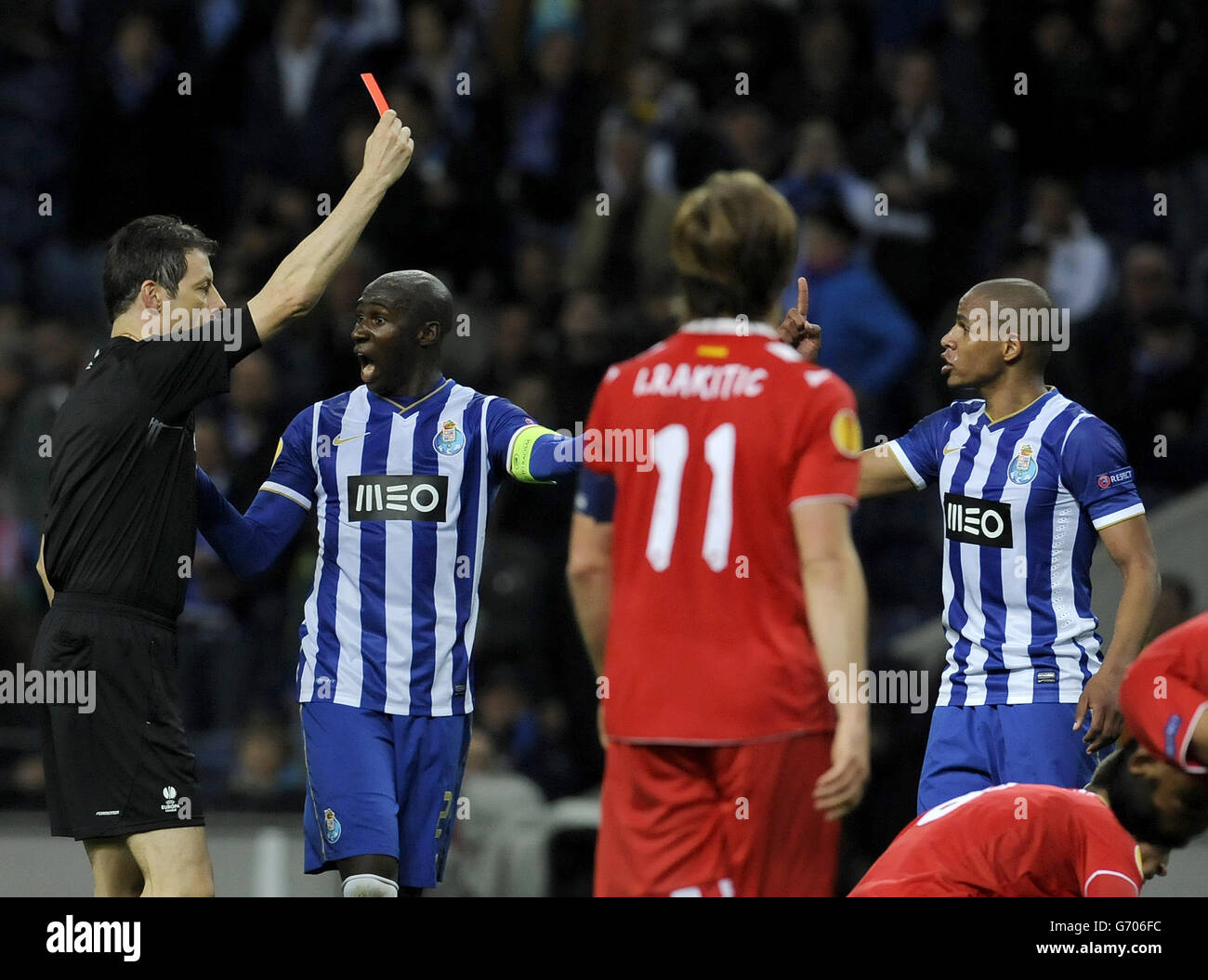FC Porto's Fernando Reges, right, from Brazil is shown a red card by referee referee Wolfgang Stark, from Germany, with Eliaquim Mangala, at second left, from France during their Europa League Quarter-final, first leg soccer match at the Dragao stadium, in Porto, Portugal, Thursday April 3, 2014. Mangala scored the only goal in Porto's 1-0 victory.(AP Photo/Paulo Duarte) ... Portugal Soccer Europa League ... 03-04-2014 ... Porto ... Portugal ... Photo credit should read: Paulo Duarte/AP. Unique Reference No. 19471204 ... Stock Photo