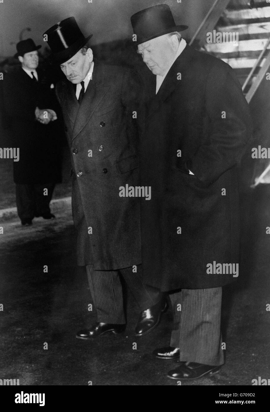 Opponents in politics but united in grief at the loss of their sovereign, King George VI, are Opposition leader Clement Attlee (l) and Prime Minister Winston Churchill at London airport as they waited to greet the new Queen Elizabeth. The Queen and her husband, the Duke of Edinburgh, were about to arrive from Kenya, where their Commonwealth tour was cut short by the death of the King. Stock Photo