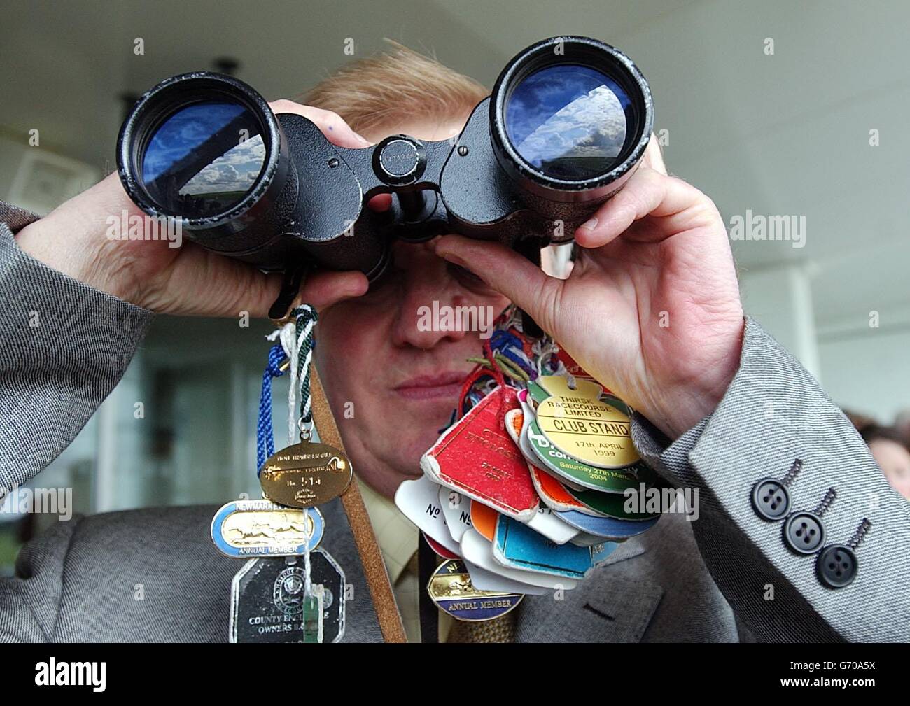 A punter keeps his eye on the 3.15 at Newmarket. Stock Photo