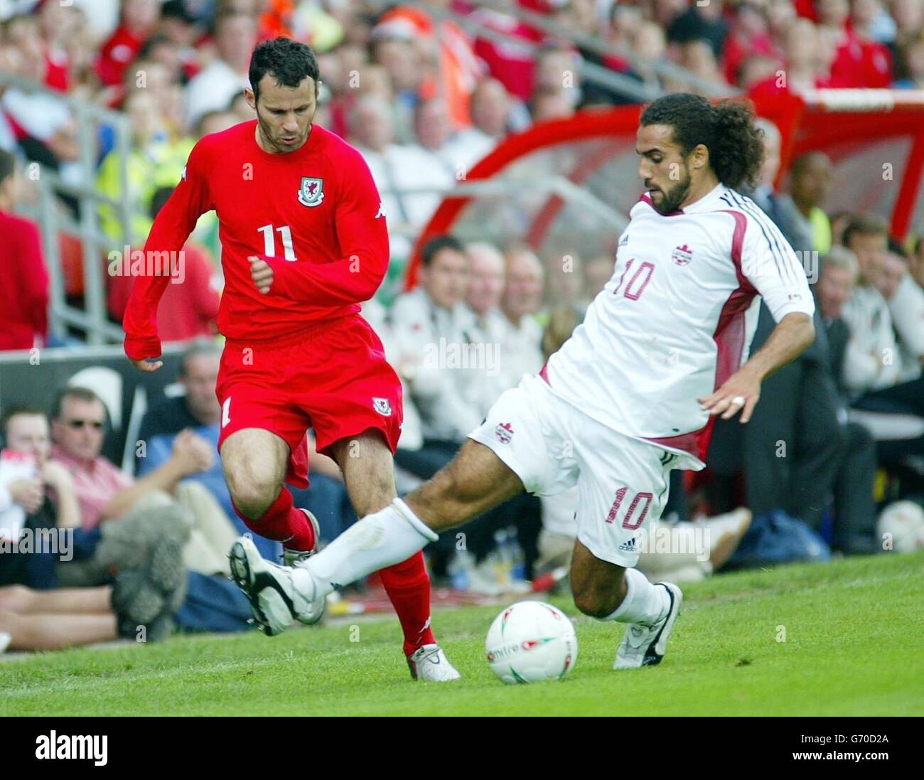 Ryan Giggs (left) of Wales is challenged by Canada's Dwayne De Rosario, during their international friendly match at the Racecourse Ground. Stock Photo