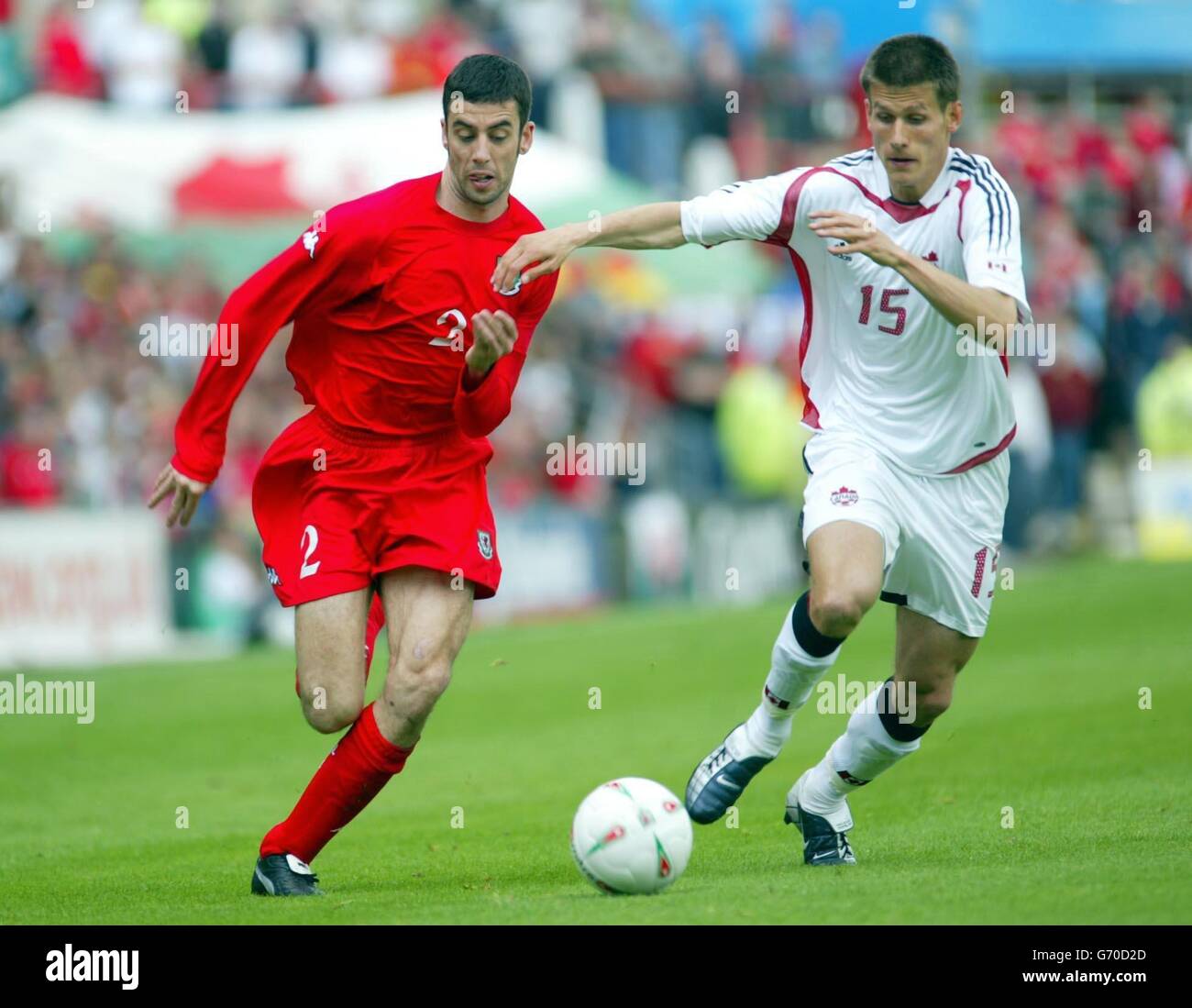 Mark Delaney (left) of Wales challenges Canada's Mike Klukowski, during their international friendly match at the Racecourse Ground. Stock Photo