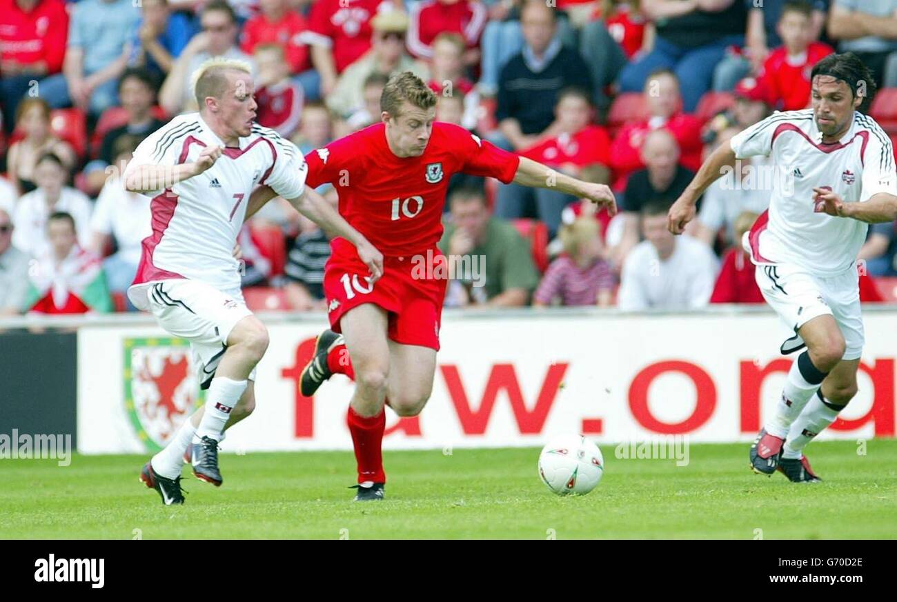 Paul Parry (centre) of Wales takes on Canada's Iain Hulmell (left), during their international friendly match at the Racecourse Ground. Stock Photo