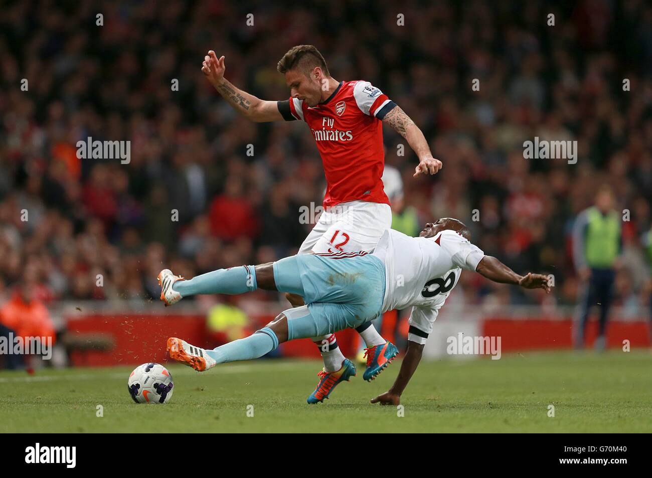 West Ham United's Pablo Armero (right) and Arsenal's Olivier Giroud battle for the ball Stock Photo
