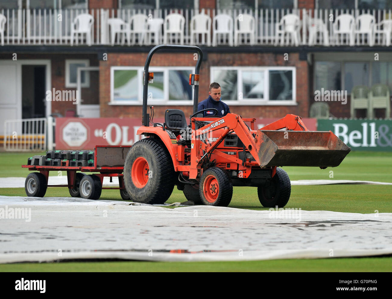 Ground staff tend to the covers as the start of play is delayed during the LV County Championship, Division Two match at The 3aaa County Ground, Derby. Stock Photo