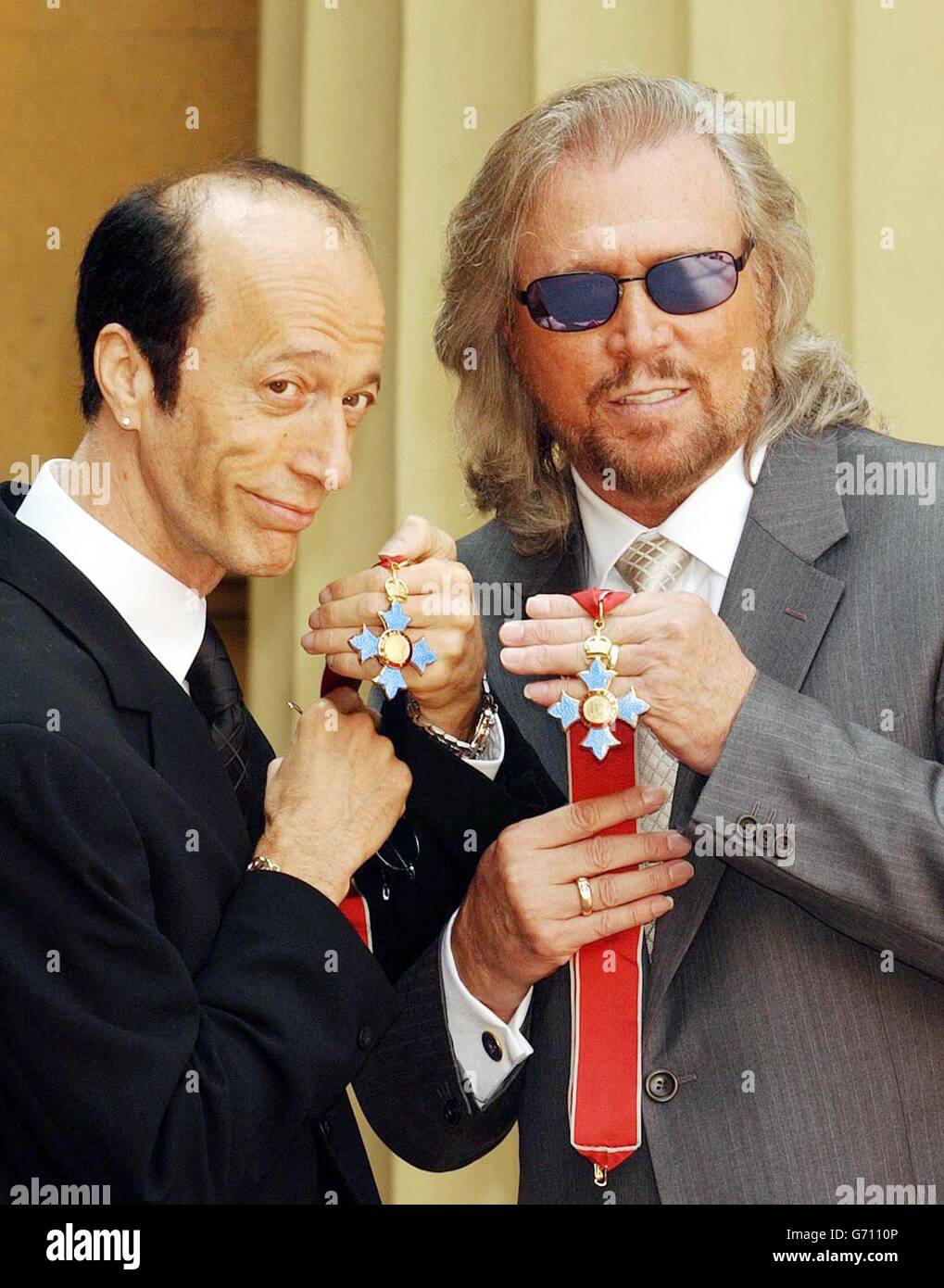 The two surviving members of the Bee Gees, Robin (left) and Barry Gibb hold their CBE's after receiving them from the Prince of Wales at Buckingham Palace, London. The third brother, Maurice Gibb, died last year before he could receive the honour and so his son Adam collected it on his behalf. Stock Photo