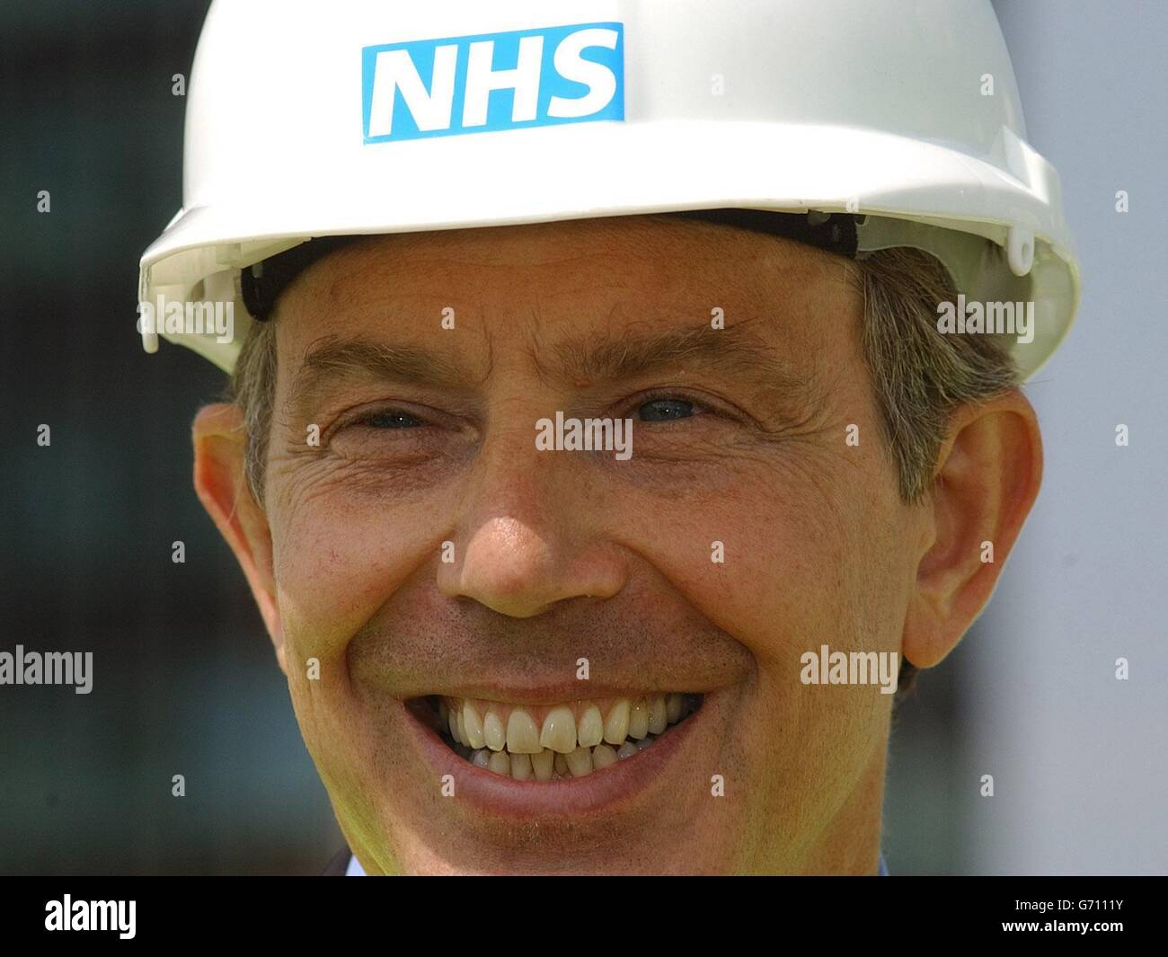 Prime Minister Tony Blair wears an NHS safety helmet during a visit to