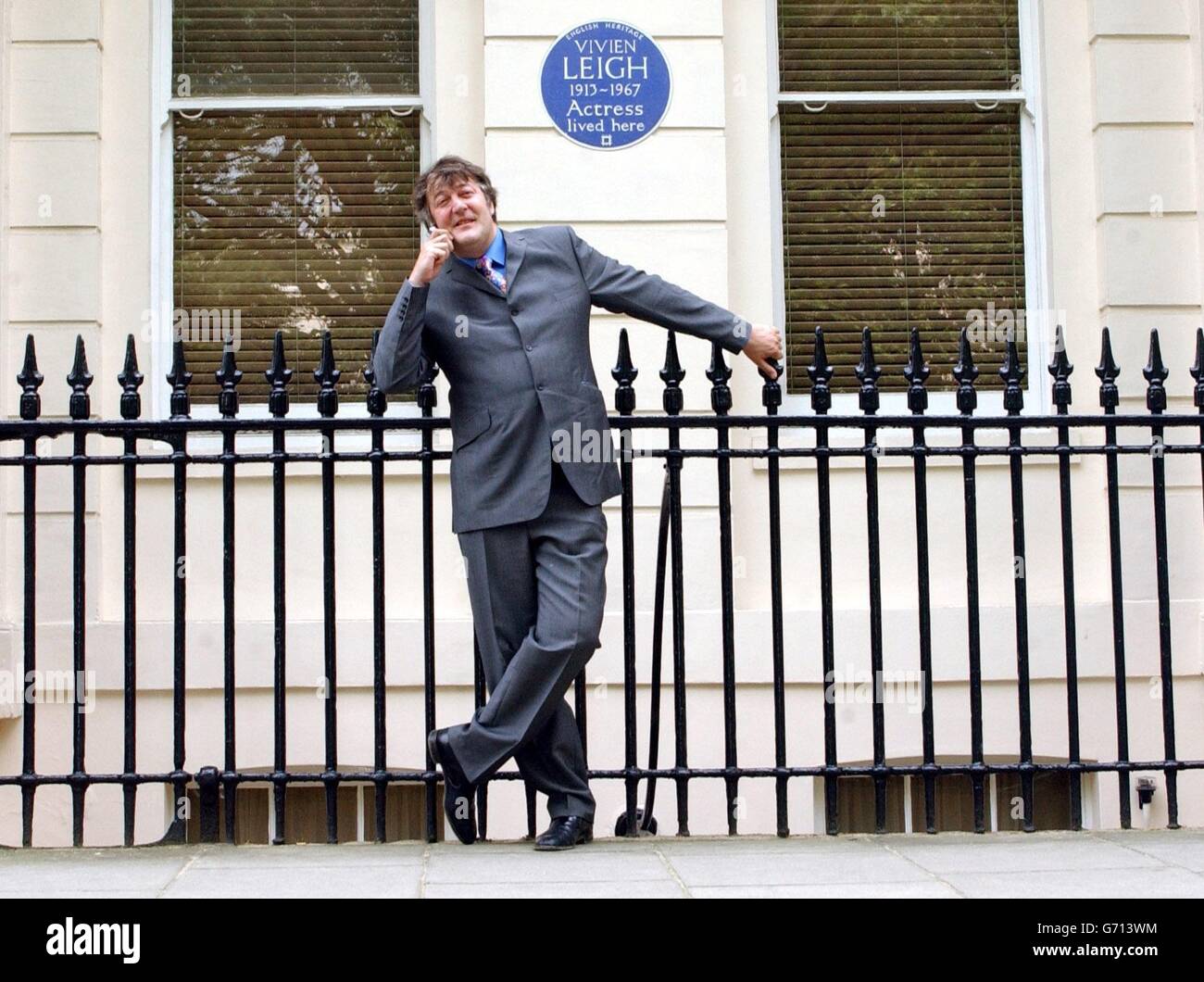 Actor and writer Stephen Fry poses outside 54 Eaton Square in London - the former home of actress Vivien Leigh - during the launch of 'Handheld History'. The innovative new guide for mobile phone users links them to the lives of famous figures commemorated with English Heritage Blue Plaques in Central London. Stock Photo