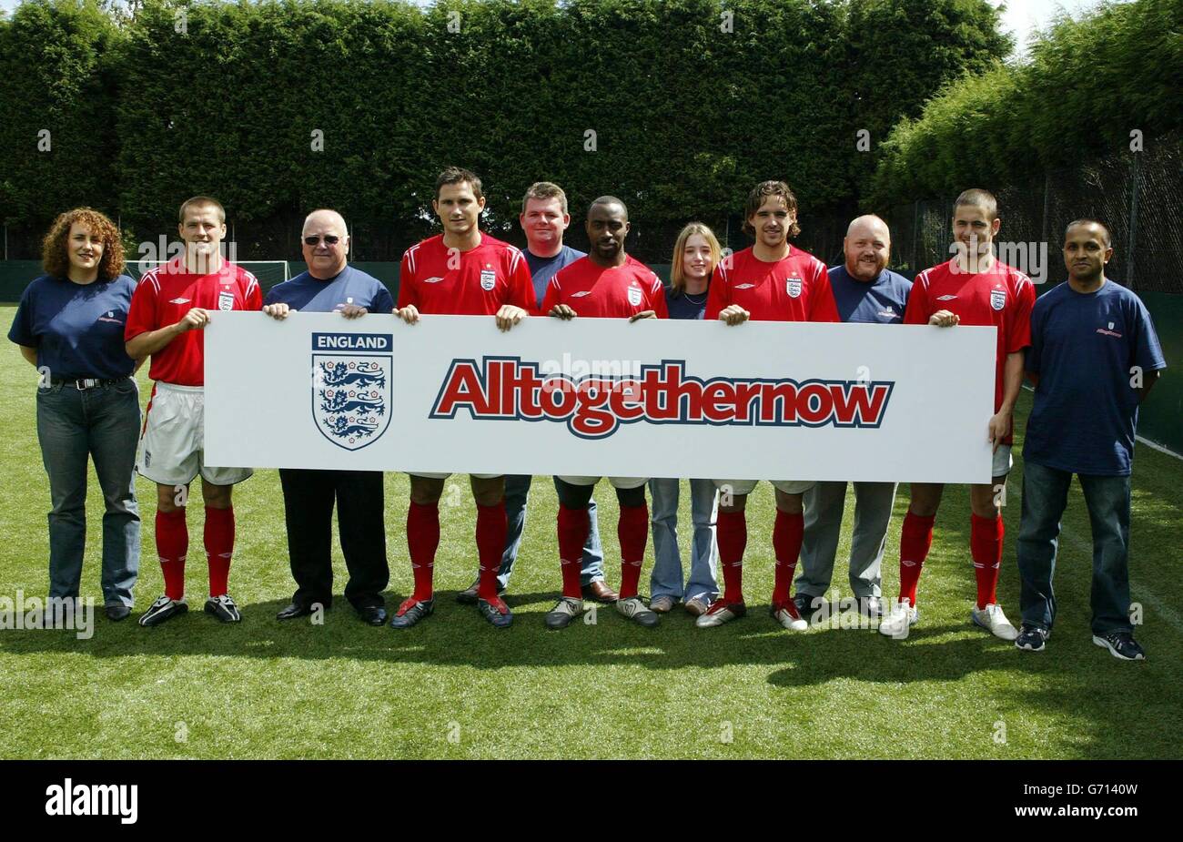 Six lucky England fans from the FA's official supporters group meet in Manchester with England players (in red, from left) Michael Owen, Frank Lampard, Darius Vassell, Owen Hargreaves and Joe Cole in Manchester, in supports of the FA's Alltogethernow campaign which promotes positive fan support at the Euro 2004 championships in Portugal. . Stock Photo