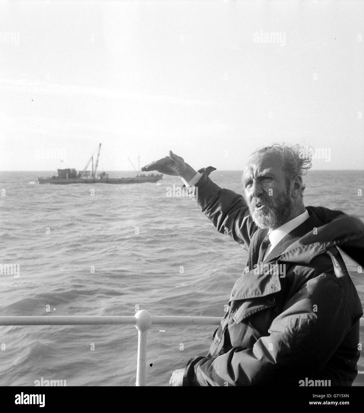 Wind blown Mr Ernest Marples, Minister of Transport, stands at the rail of the Trinity House vessel Patricia during his mid-Channel visit to view the ships making the first borings for the geological survey for the proposed 160 million Channel Tunnel. In the background is the survey ship Cauville, one of the vessels taking part in the operation. Mr Marples and his French counterpart, Marc Jacquet, spent five hours on a blustery sea. Later, Mr Marples said that in his view the tunnel was ' a certainty'. Stock Photo