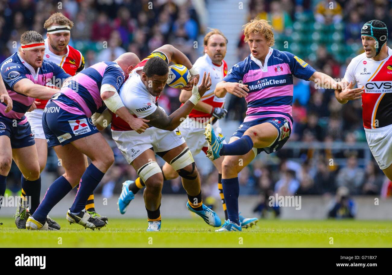 London Wasps' Nathan Hughes (centre) is tackled by Gloucester's Nick Wood (left) and Billy Twelvetrees (rigth) during the Aviva Premiership match at Twickenham, London. Stock Photo