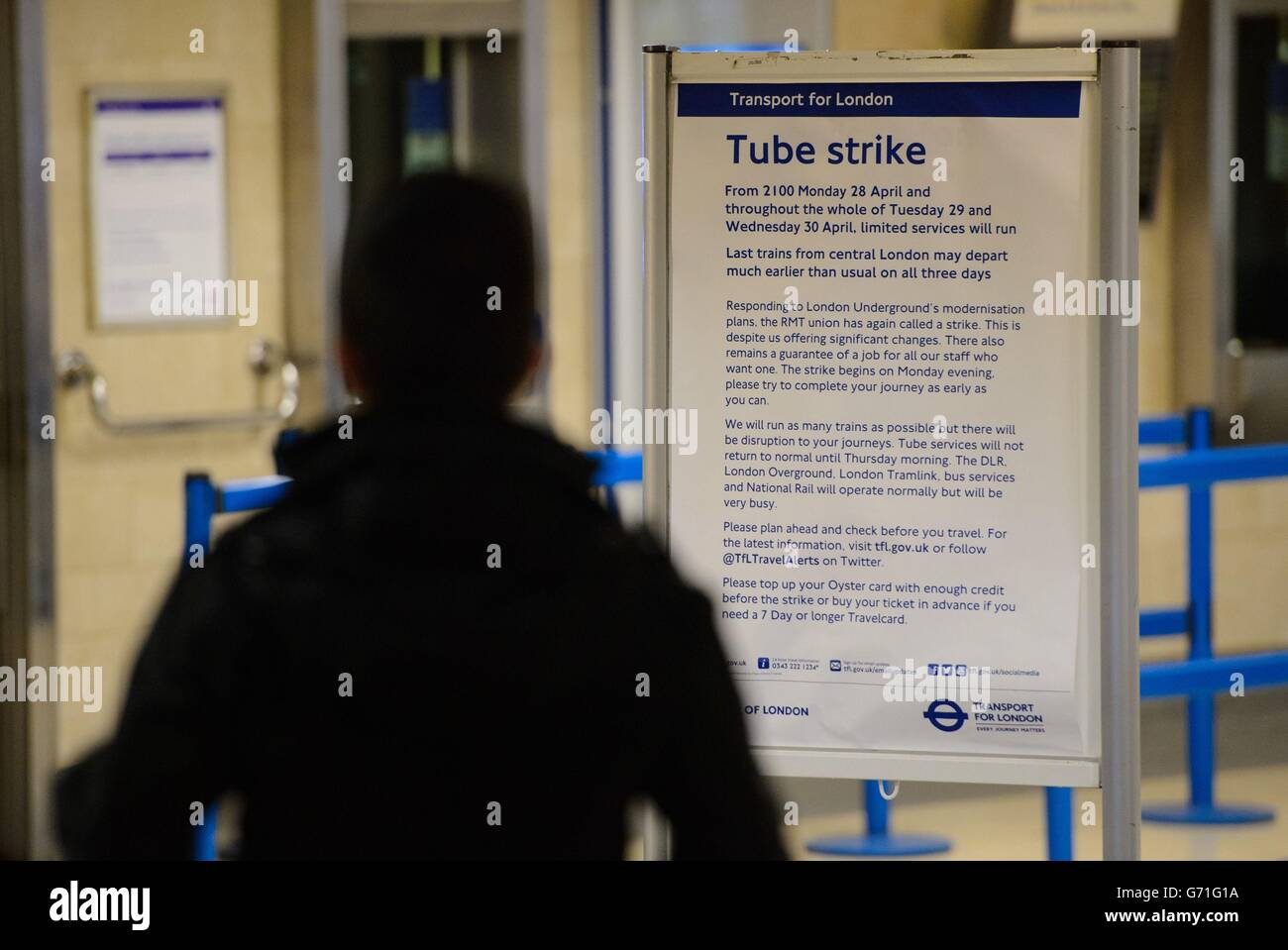 A passenger at Tower Hill station, in central London, passes a sign giving notice of the start of 48 hours of industrial action by RMT union members affecting the London Underground in a row over ticket office closures. Stock Photo