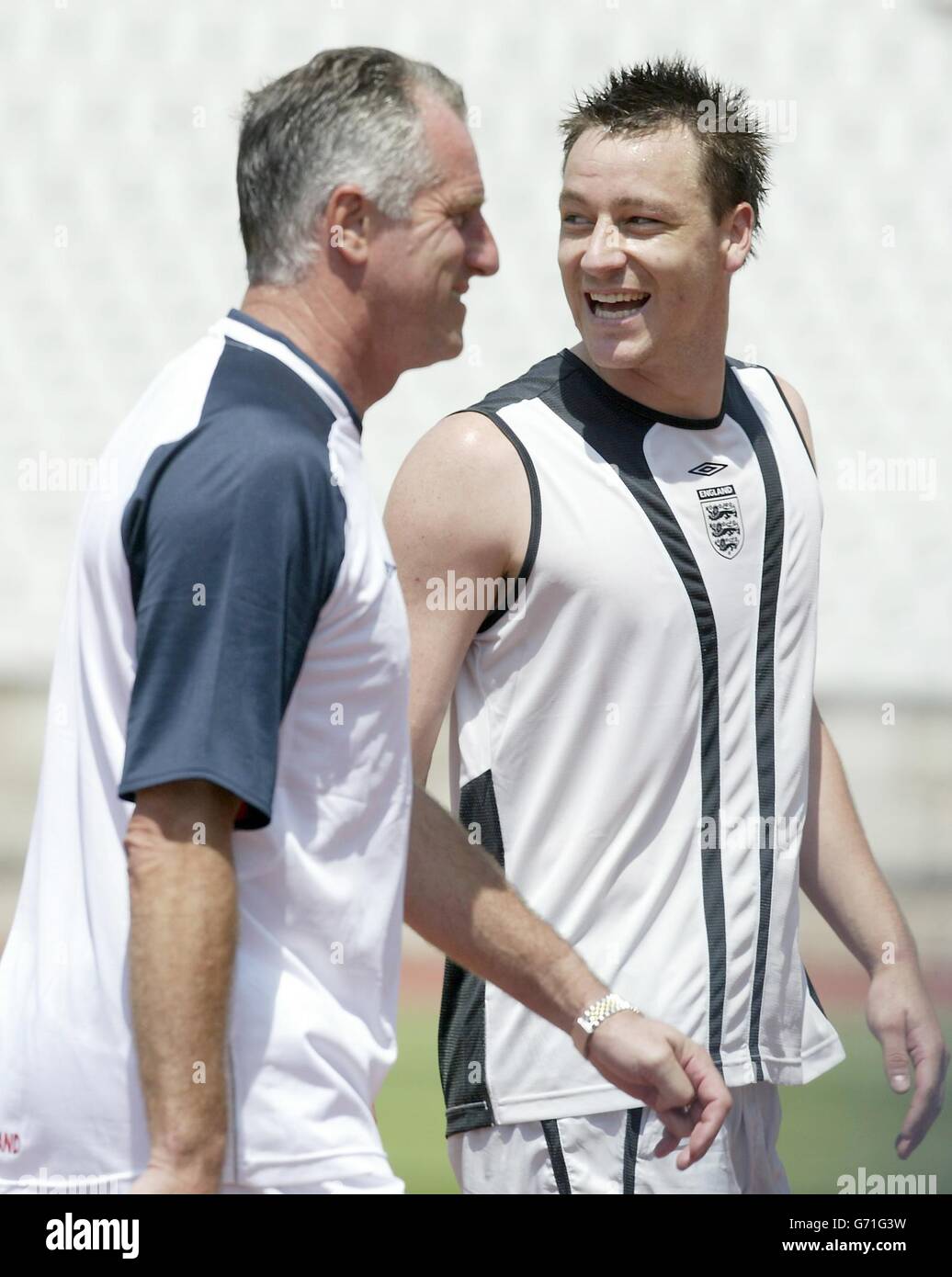 England defender John Terry walks off the pitch with coach Ray Clemence before an England training session at the National Stadium in Lisbon, in preparation for the opening Euro 2004 match against France this Sunday. , NO MOBILE PHONE OR PDA USE. INTERNET USE ONLY ON UEFA AUTHORISED SITES. Stock Photo