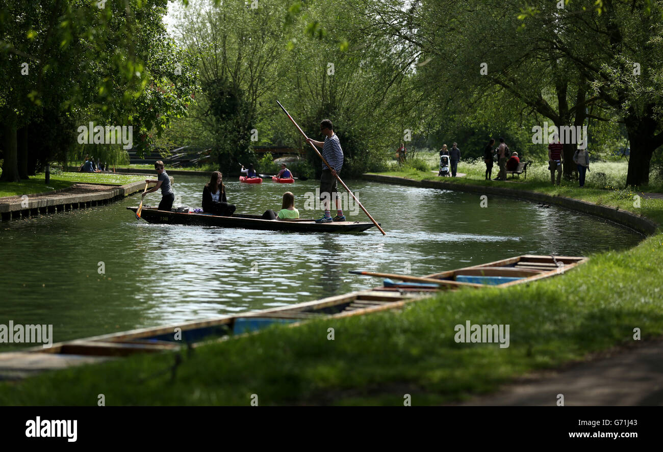 People punting on the River Cam in Cambridge as they enjoy the May Day Bank Holiday sunshine. Stock Photo