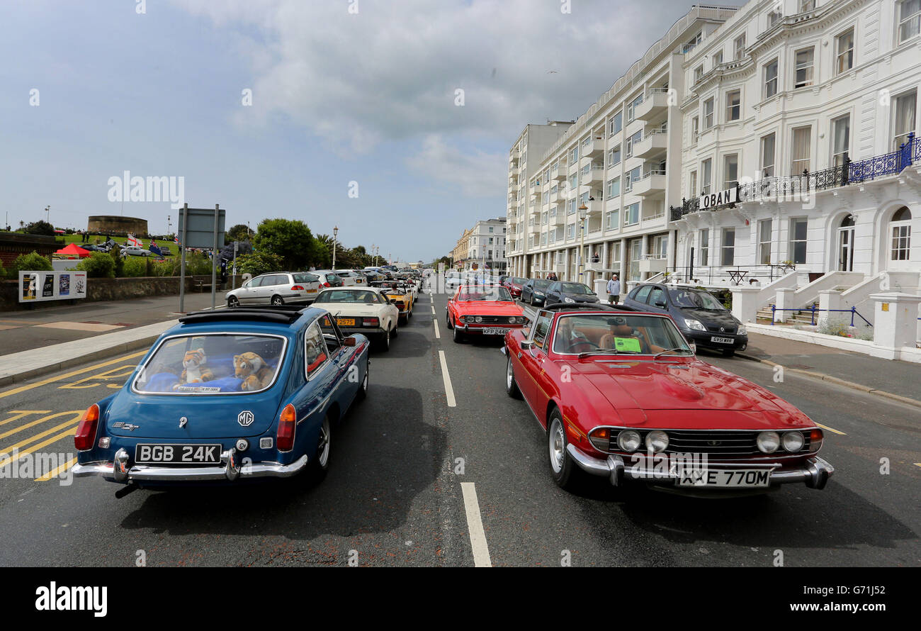 Classic cars are driven along the seafront in Eastbourne, Sussex, at the start of the second day of Magnificent Motors, as around 600 vintage and classic vehicles take part in the largest free motoring spectacular on the south coast. Stock Photo