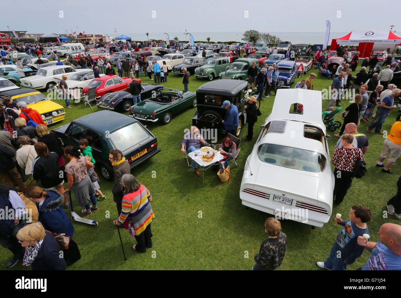 A couple picnic in the fine weather next to their classic car in Eastbourne, Sussex, during the second day of Magnificent Motors, as around 600 vintage and classic vehicles take part in the largest free motoring spectacular on the south coast. Stock Photo