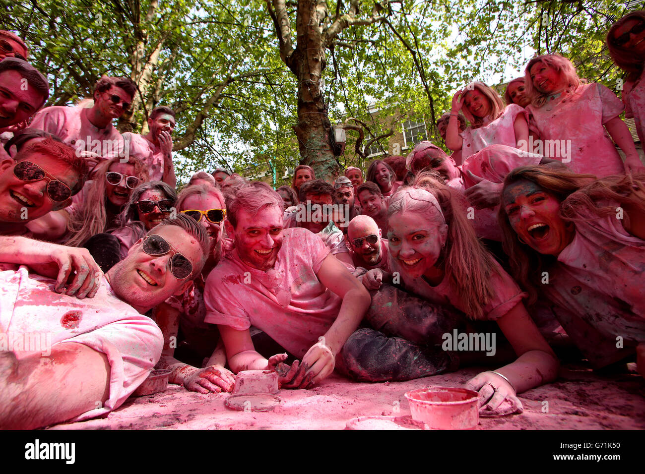 EDITORIAL USE ONLY Revellers throw fresh raspberries and powder paint to celebrate the return of Kopparberg Raspberry, at Vibe Bar in Brick Lane, east London. Stock Photo