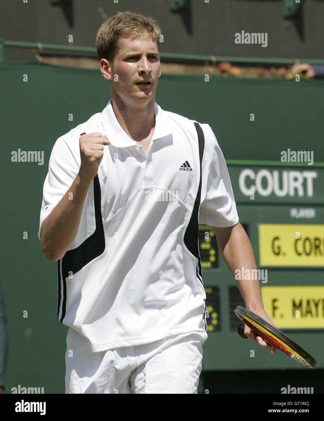 Florian Mayer from Germany punches the air after defeating the number three seed Guillermo Coria from Argentina at The Lawn Tennis Championships in Wimbledon, London. Mayer won in four sets 4:6/6:3/6:3/6:4. Stock Photo