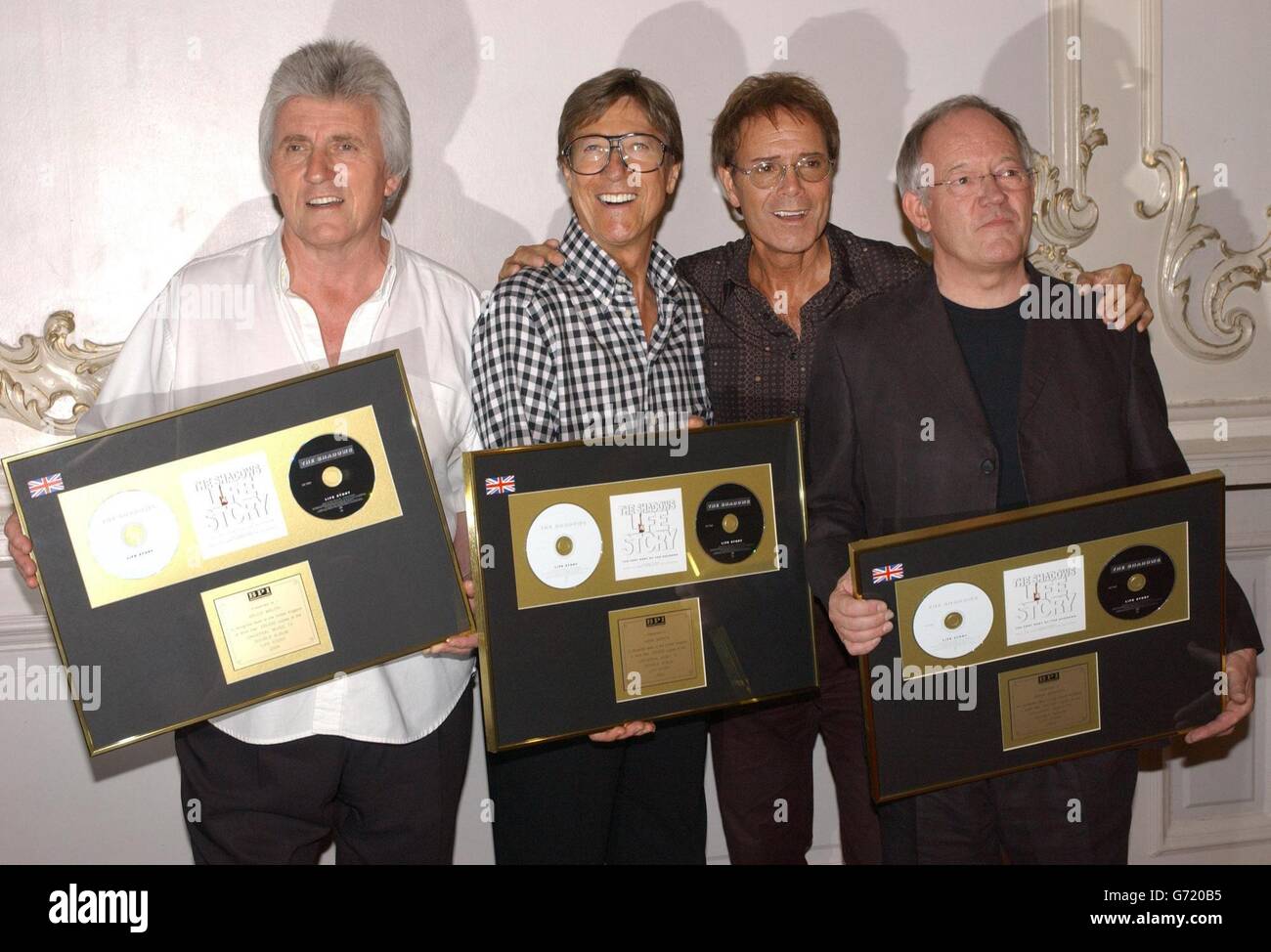 Sir Cliff Richard (second right) with the Shadows, (from left) Bruce Welch, Hank B Marvin and Brian Bennett at the London Palladium, ahead of their final concert appearance together, which will see Sir Cliff sing three numbers. Band members Marvin, Bruce Welch and Brian Bennett have been touring the UK for the last time in their 45-year career, playing 37 sellout dates before their last ever performance. The group are holding gold discs to mark more than 100,000 sales of their recent double CD Life Story - The Very Best Of The Shadows. Stock Photo