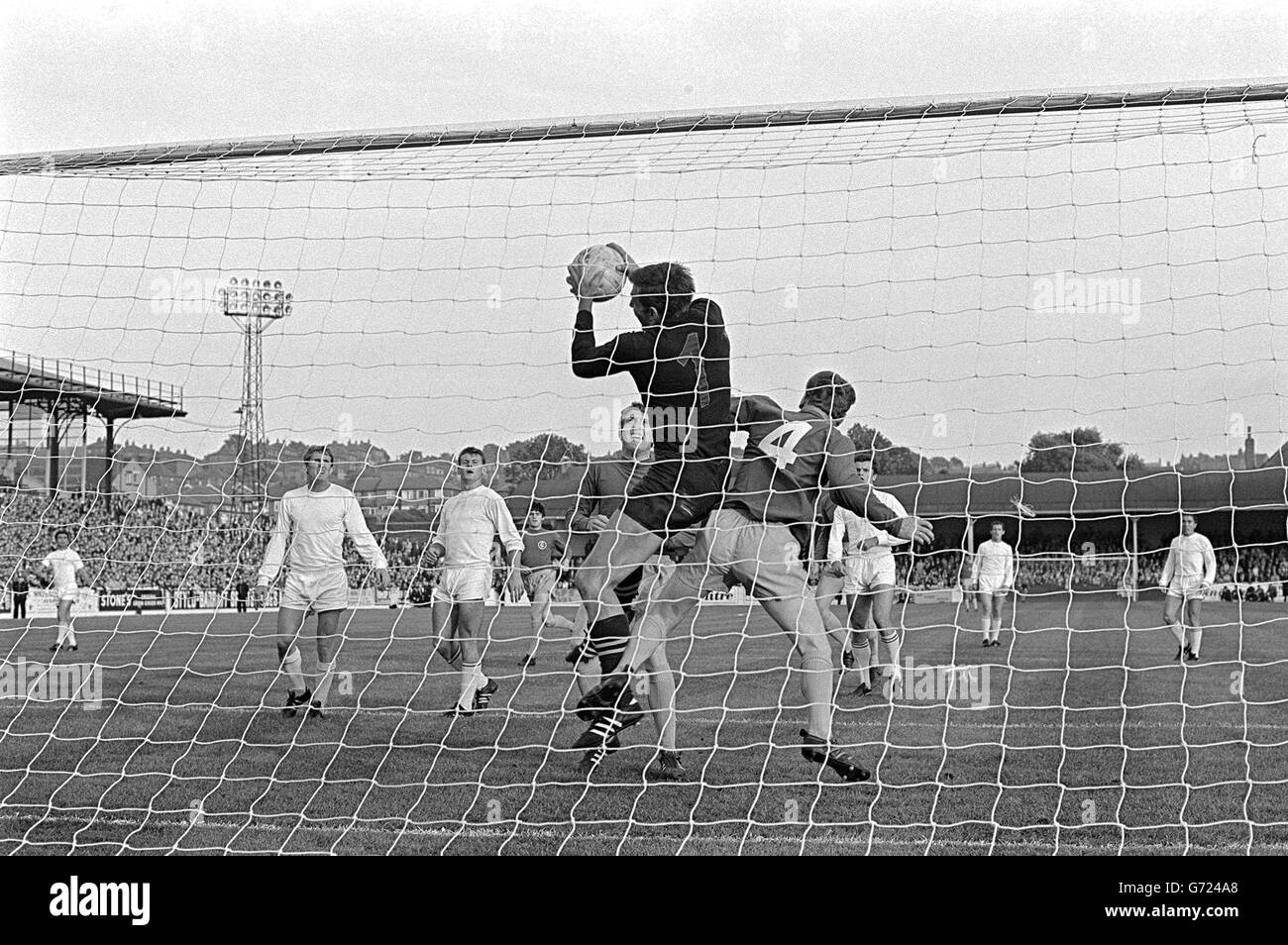 Geczi, the Ferencvaros (Hungary) goalkeeper, leaps to avoid Billie Bremner of Leeds United in the goalmouth and take the ball during the Inter-Cities Fairs Cup Final (first leg) at Elland Road, Leeds. Jones of Leeds runs in. Stock Photo
