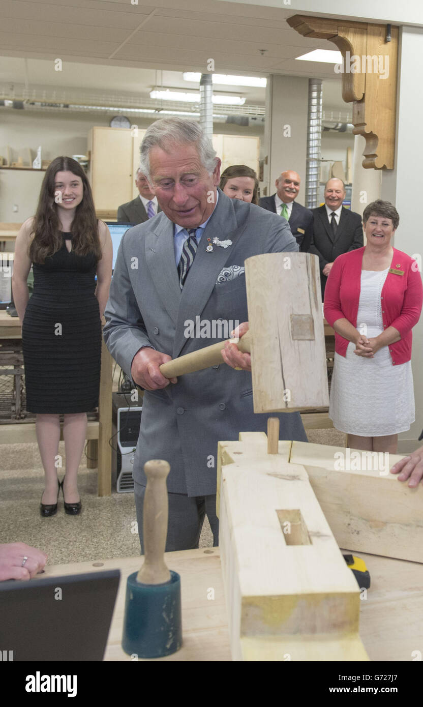 The Prince of Wales hammers in a peg with a giant mallet as he visits