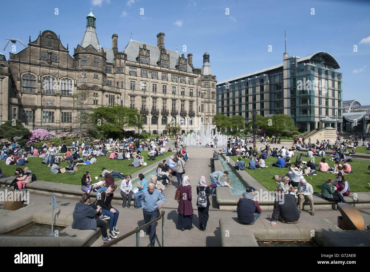People enjoy the hot spring weather at the Peace Gardens in Sheffield city centre today. Stock Photo