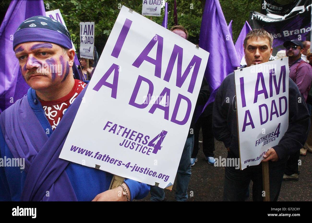Members of 'Fathers 4 Justice' demonstrate during their march to Westminster, London where they are staging a protest for more rights for fathers. Women and children joined the march, most dressed in purple with their faces painted. The procession was headed by a giant purple helium balloon with the 'super heroes' bus following, which pumped out loud music. Stock Photo