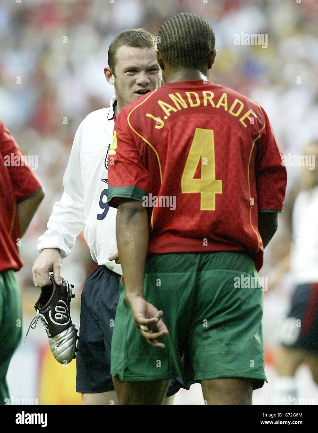 England's Wayne Rooney confronts Portugal's Jorge Andrade, after being injured, during the Euro 2004 quarter-final match at the Estadio de Luz, Lisbon, Portugal. Stock Photo