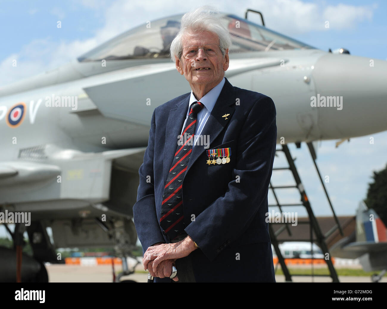 D-Day veteran Paddy Byrne at Coningsby to watch a Eurofighter Typhoon accompanied by a D-Day Spitfire perform a low-level fly past over RAF Coningsby adorned with commemorative D-Day stripes ahead of the 70th anniversary of the landings at RAF, Coningsby, Linconlshire. Stock Photo
