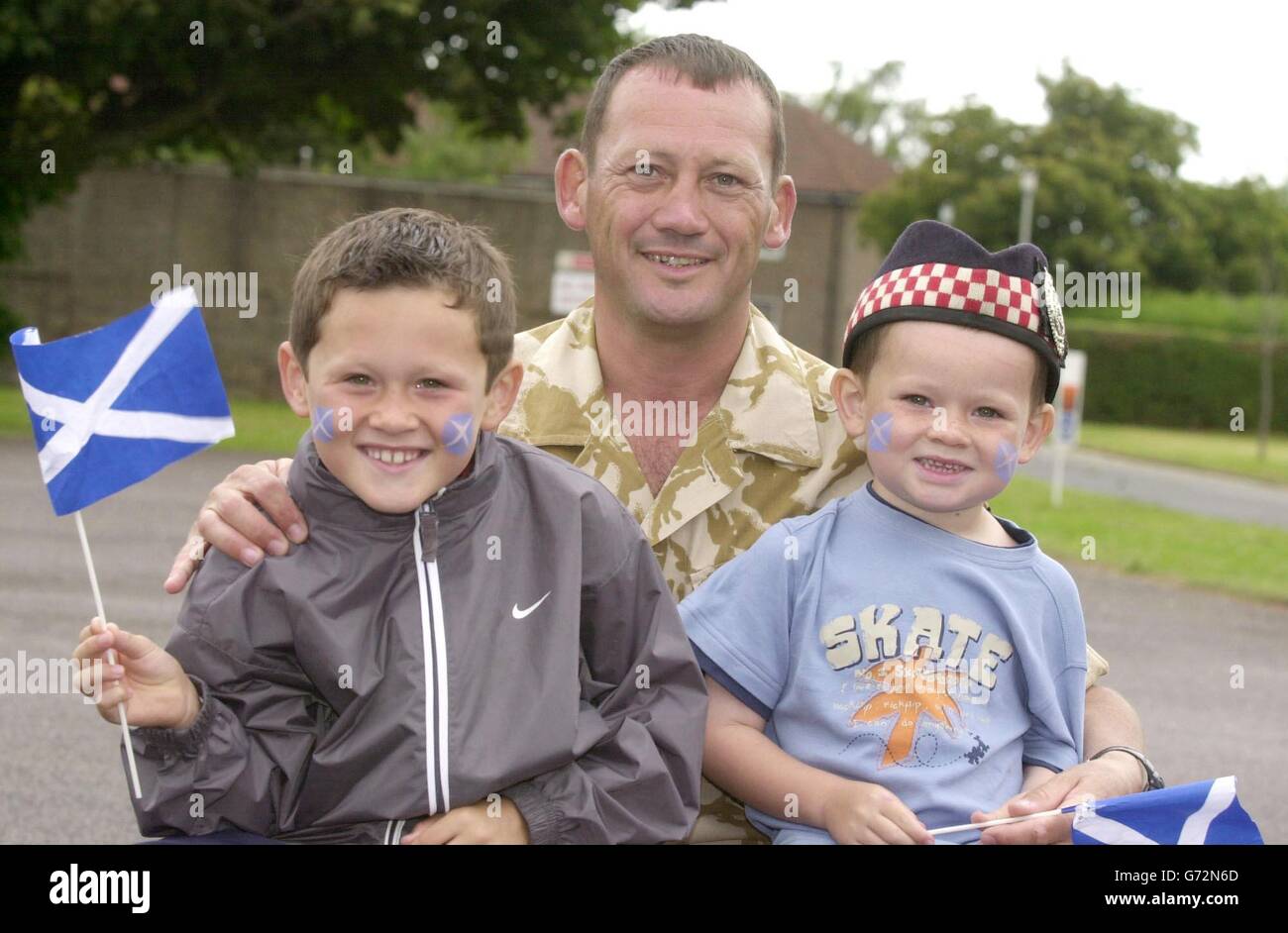 Sgt. Danny Dunn with his sons Cameron (left), 8, and Conrad, 4, at Howe Barracks, Canterbury, where more than 200 soldiers were reunited with their families. Families waved and cheered as troops of the 1st Battalion, the Argyll and Sutherland Highlanders, were officially dismissed at the Barracks. Stock Photo