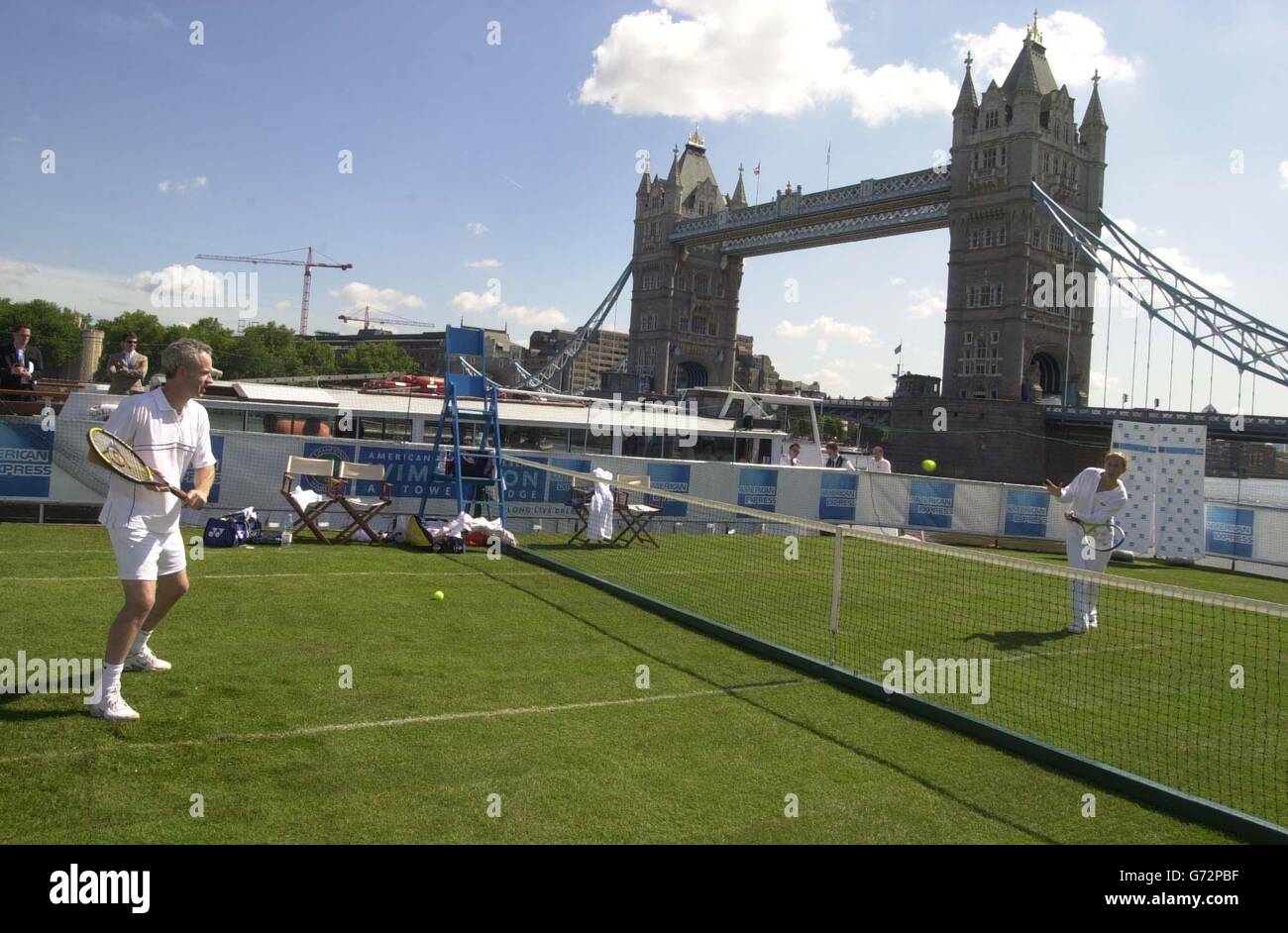 Tennis stars John McEnroe in action against Monica Seles play tennis on a floating court on the River Thames in London. The court is traveling from Waterloo Pier to London's Tower Bridge aboard a barge. Stock Photo