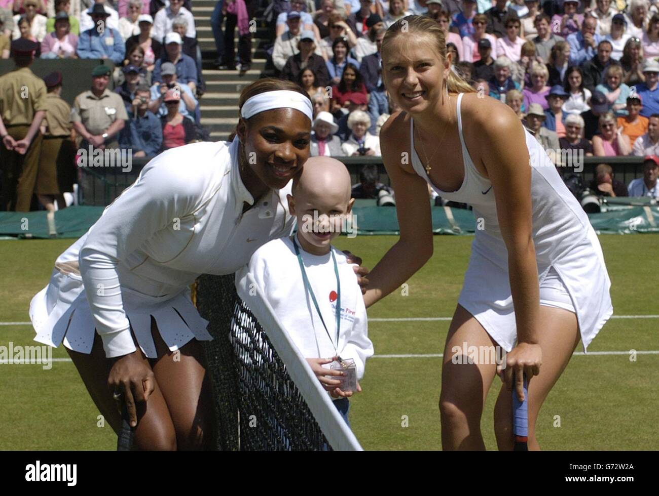 Five year old Emily Bailes from Walsall in the West Midlands who performed the coin toss to decide who would serve first between Serena Williams (left) and Maria Sharapova in the final of the Ladies' Singles tournament at The Lawn Tennis Championships at Wimbledon, London. Emily was representing the Birmingham Children's Hospital Charity which raises money to purchase equipment for the hospital. She was assisted by the tournament referee Alan Mills and the match umpire Alison Lang. , NO MOBILE PHONE USE. Stock Photo