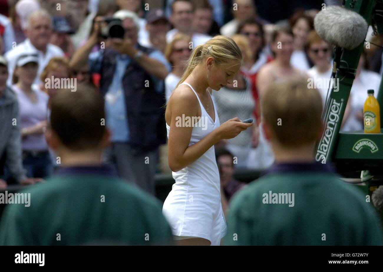 Maria Sharapova from Russia attempts to call her mother in America using a mobile phone after defeating Serena Williams in straight sets 6:1/6:4 in the final of the Ladies' Singles tournament at The Lawn Tennis Championships at Wimbledon, London. Stock Photo