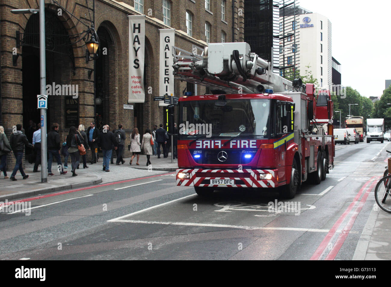 A London Fire Bridgade aerial ladder platform responding to an emergency call outside London Bridge Station, London. Stock Photo