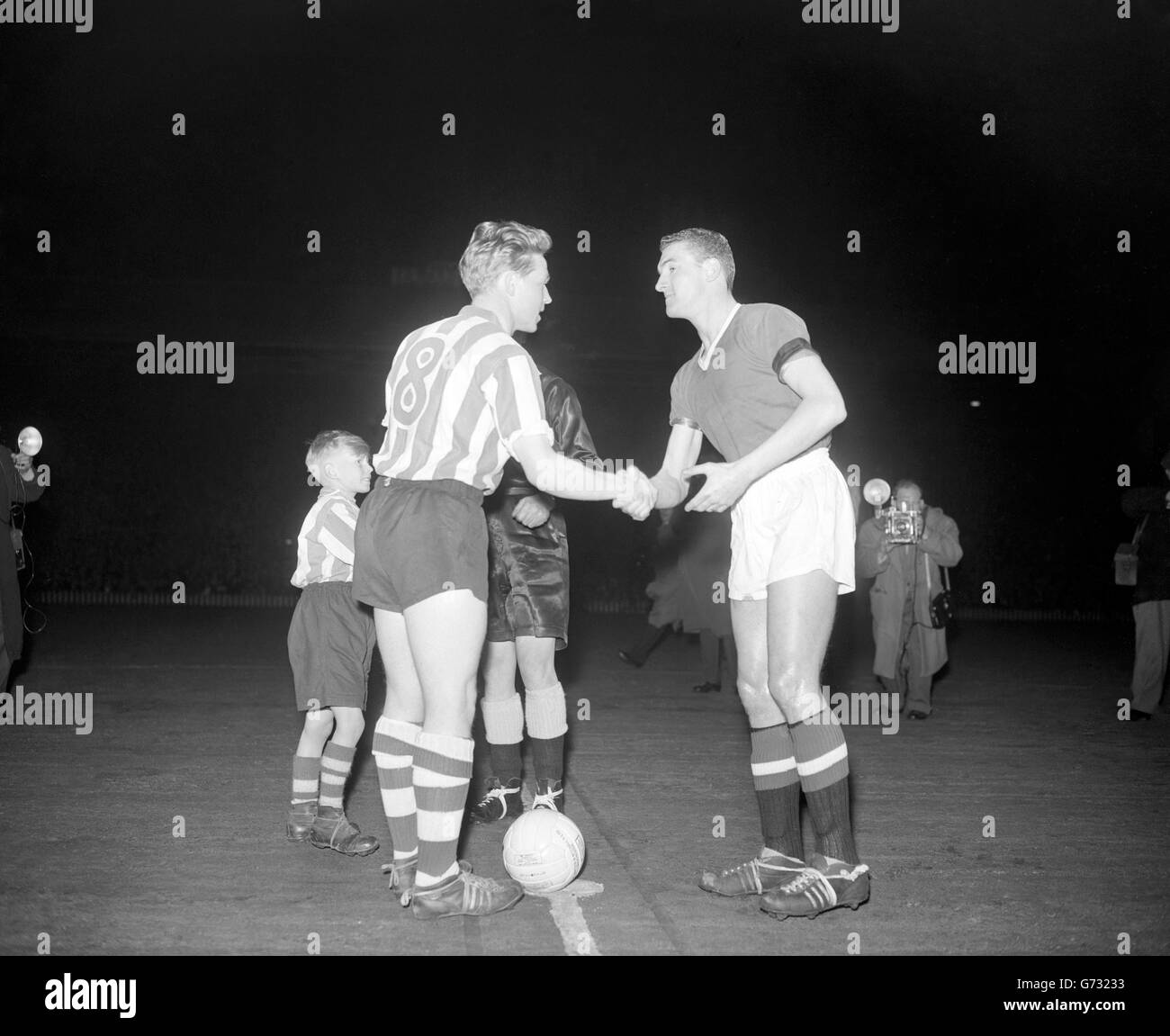 Manchester United's new captain Billy Foulkes (right) shakes hands with Sheffield Wednesday skipper Albert Quixall before the kick off in the FA Cup tie at Old Trafford. United beat Wednesday 3-0. Stock Photo